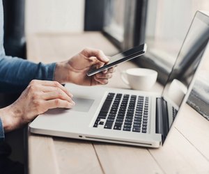 Young man using laptop computer and smart phone