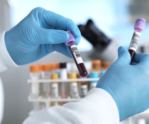 Hand holding blood sample in laboratory