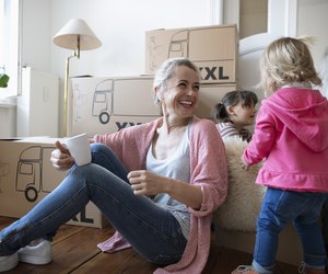Happy mother and daughters taking a break from moving