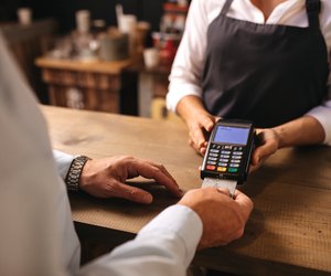 Customer doing payment of coffee by credit card at cafe