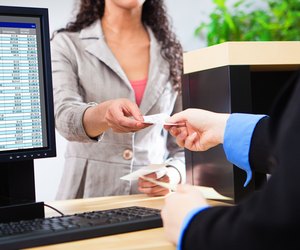 Bank Teller Working with Customer at Bank Counter in Retail Bank