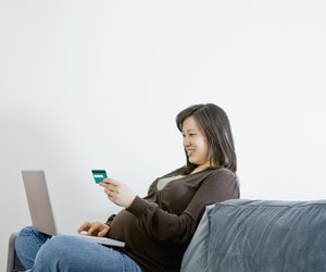 Pregnant Asian woman buying merchandise over the internet