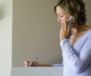Woman talking on phone and writing