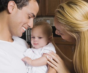 Hispanic parents smiling at baby