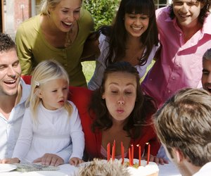 Woman blowing out candles at party
