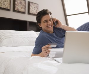Man using cell phone in bed at home