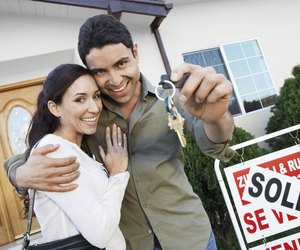 Happy Homeowners with <Sold> Sign