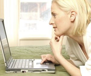Woman using laptop computer in hotel room