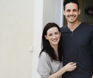 happy young couple welcome in new house at door entrance