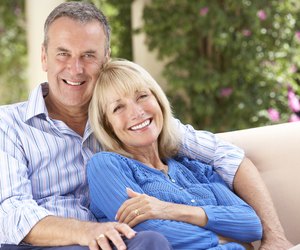 Senior Couple Relaxing On Sofa At Home