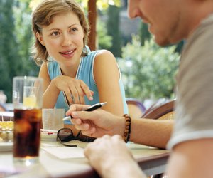 Couple having drink at outdoor cafe (focus on woman)