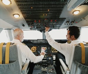 Portrait of Pilots Sitting in the Cockpit, Adjusting the Controls