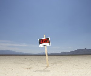 'For sale' sign in dry lake bed