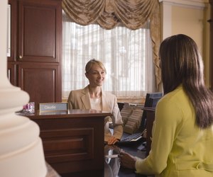 Woman at bank counter conversing with teller