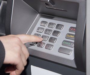 Woman pressing number button on ATM machine