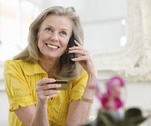 Mature Woman Using Credit Card And Phone