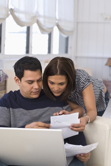 couple paying bills on computer