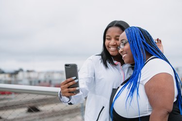 Mother and daughter family taking a selfie with a mobile smart phone device