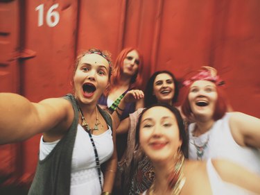Group of laughing girlfriends taking a group selfie