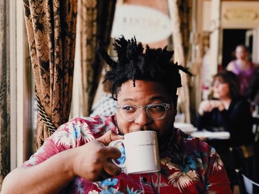 Black man in Hawaiian shirt drinking coffee from mug