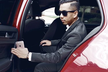 Dapper Asian man getting out of luxury car