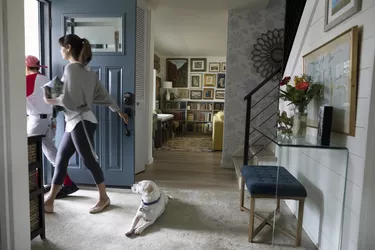 Dog watching mother and son leaving for baseball practice at front door