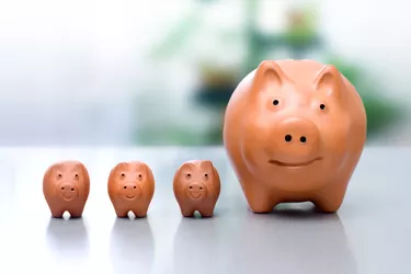 Set of three small and one large orange piggy banks