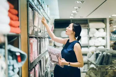 Smiling young pregnant woman shopping for home necessities in shop