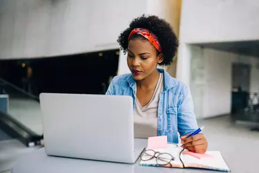 Focused young African entrepreneur hard at work on a laptop