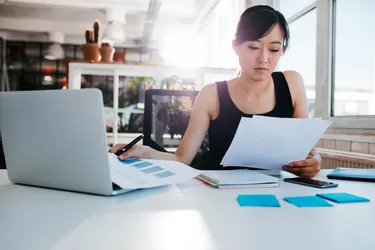 Businesswoman doing paperwork at her workplace