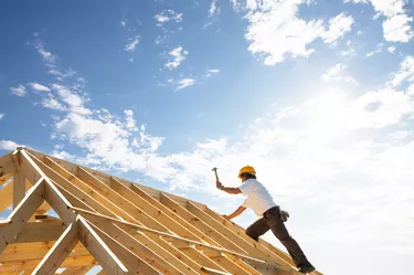 roofer worker builder working on roof structure at construction site