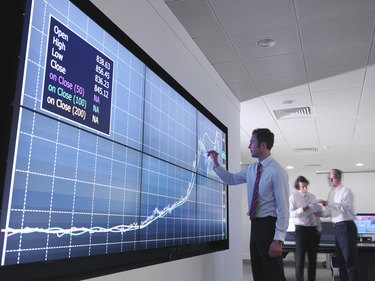 Businessman using graphs on screen