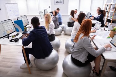 Group Of Businesspeople Discussing While Working In Office