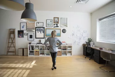 Young woman looking at frame wall in studio