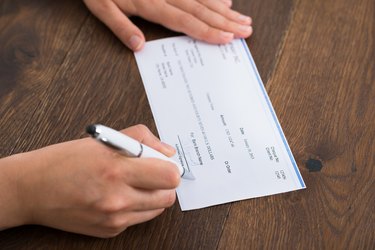 Person Hands Signing Cheque