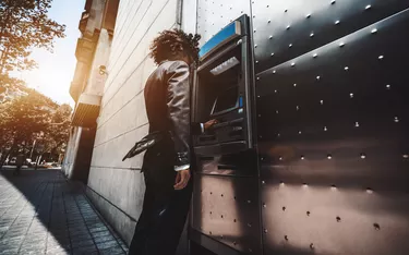 The businessman is using street ATM