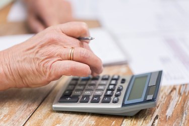 How to Calculate Pension Benefits              close up of senior woman counting with calculator