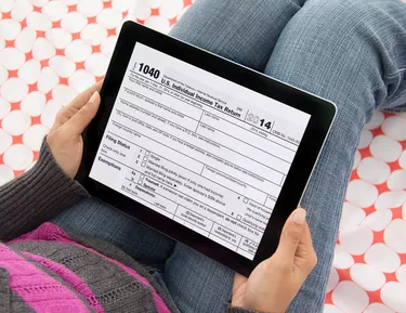 Characteristics of Taxes                         Person filing income tax returns online using tablet computer