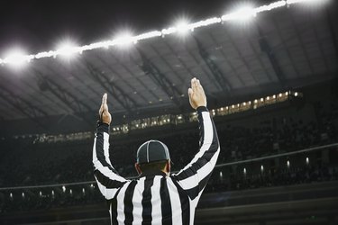 Football referee signaling touchdown in stadium