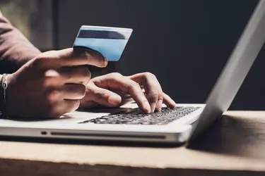 Man shopping online using laptop computer and credit card