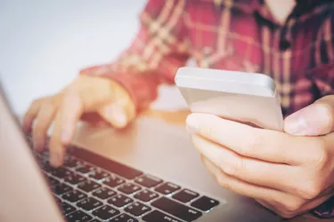 Man hand holding smartphone and credit card doing online banking.  shopping online