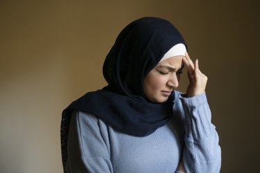 Stressed Muslim woman hand on head