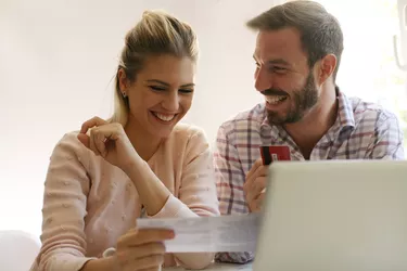 Cheerful couple paying bills.