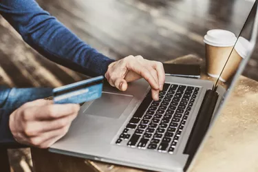 Man shopping online using laptop computer and credit card