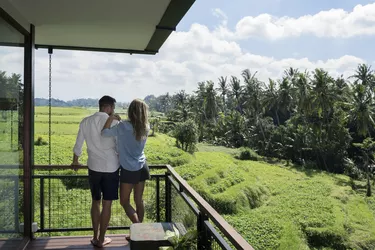 Couple standing on balcony, enjoying the landscape