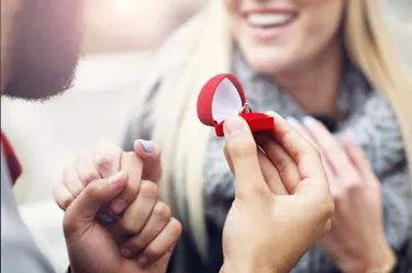 Adult man giving engagement ring to beautiful woman