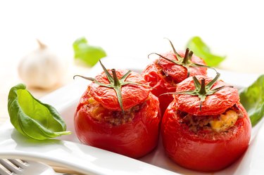 Baked stuffed tomatoes served with fresh basil