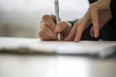 Hands of a person writing on a notepad