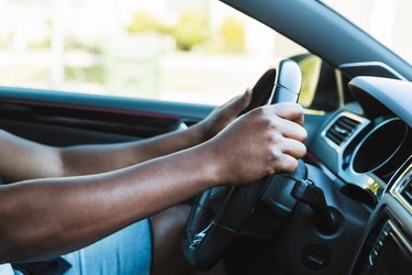 Strong, unrecognizable mid adult man drives his car