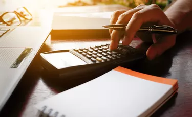 Businessman hand calculate bout cost with laptop for search data.